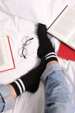 Yatakta siyah çorap giyen bir kadın.