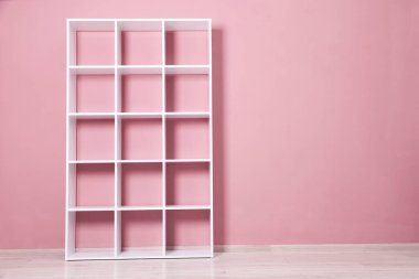 İçerideki pembe duvarın yanındaki boş raf ünitesi. Metin için boşluk