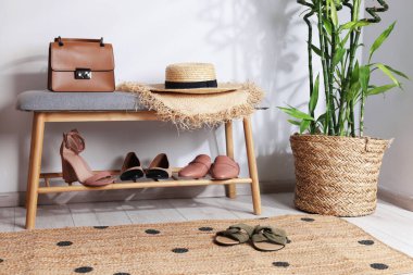 Farklı şık ayakkabılar, hasır şapkalar, poşetler ve ev bitkileriyle ayakta durun.