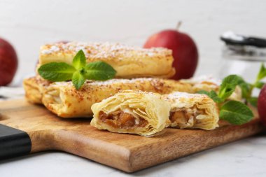 Pudra şekerli elmalı turtalar ve beyaz mermer masada nane şekeri, yakın plan.