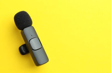 Sarı arka planda Lavalier mikrofon, üst manzara. Metin için boşluk