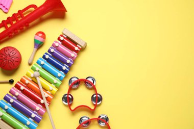 Düz kompozisyon ve sarı arka planda farklı müzik aletleri. Metin için boşluk