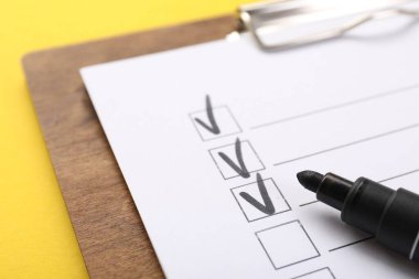 Sarı arkaplanda kontrol listesi ve işaretleyici, yakın plan