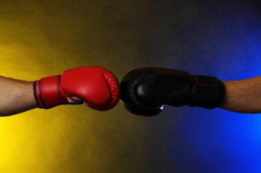 Boks eldivenli adamlar karanlık arka planda dumanla savaşıyor.