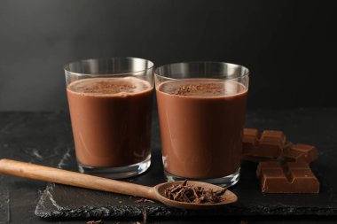 Lezzetli çikolatalı süt, talaş ve siyah masa parçaları.