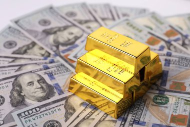 Parlak altın külçeler ve banknotlar masanın üzerinde, yakın plan. Metin için boşluk