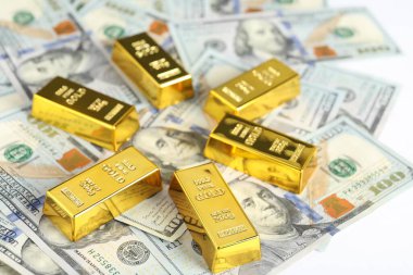 Parlak altın külçeler ve beyaz arka planda dolar banknotları, yakın plan