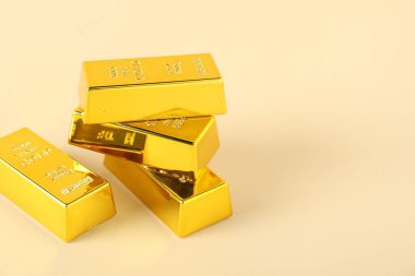 Bej arka planda parlak altın külçeler, yakın plan. Metin için boşluk