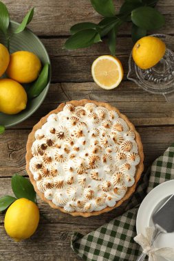 Lezzetli kremalı turta, limonlar, kek servisi ve tahta masaya sıkma, düz uzanma.