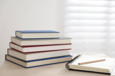 Kitaplar, defter ve kalem kapalı bir masa üzerinde. Metin için boşluk