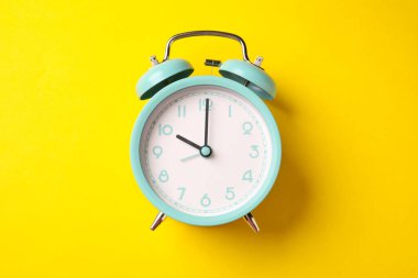 Sarı arka planda turkuaz alarm saati, üst görünüm