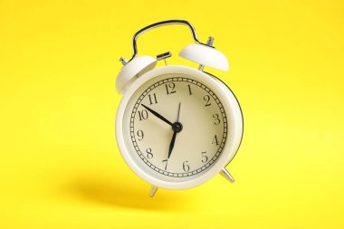Sarı zemin üzerinde beyaz alarm saati