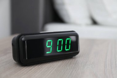 Dijital alarm saat 9: 00 'da kapalı bir masada.