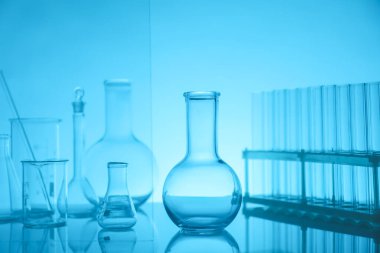 Ayna yüzeyinde açık mavi arkaplana karşı laboratuvar camları