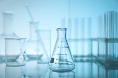 Ayna yüzeyinde açık mavi arkaplana karşı laboratuvar camları