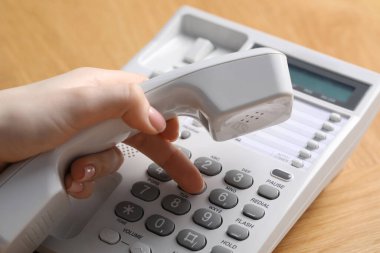 Ahşap masada telefonla arayan kadın, yakın plan.