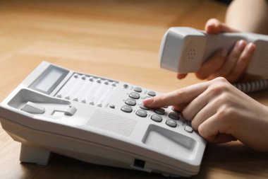 Ahşap masada telefonla arayan kadın, yakın plan.