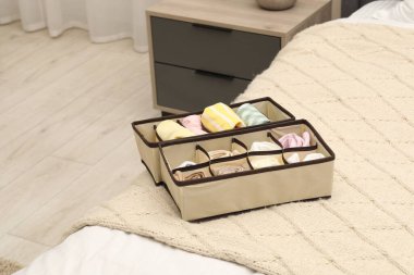 Yatağın içinde katlanmış giysileri olan organizatörler.