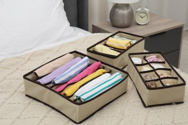 Yatağın içinde katlanmış giysileri olan organizatörler.