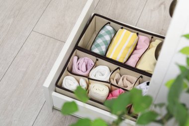 İçerideki çekmecelerde katlanmış kıyafetleri olan organizatörler.