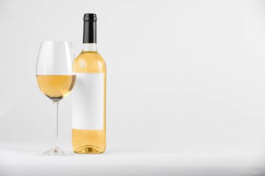 Bardakta şarap, beyaz arka planda şişe, metin için yer var.