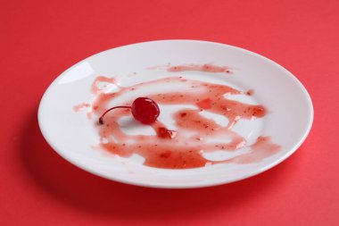 Kırmızı arkaplanda kirli bir tabak, yakın plan.