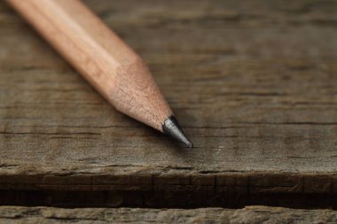 Ahşap masada keskin bir grafit kalem, yakın plan. Metin için boşluk