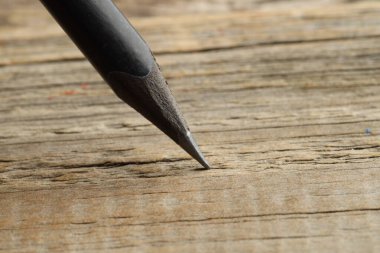 Ahşap masada keskin bir grafit kalem, yakın plan. Metin için boşluk