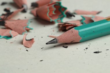 Işık arkaplanındaki grafit kalem ve talaşlar, yakın plan