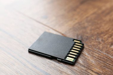 Tahta masada bir SD hafıza kartı, yakın plan.
