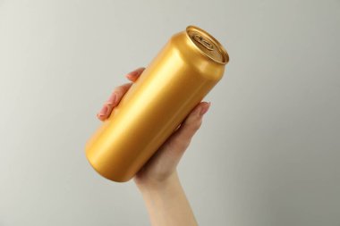 Açık gri arka planda teneke kutusu olan kadın, yakın plan.