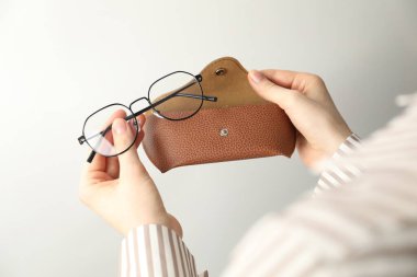 Hafif arka planda gözlüklü kadın çantası, yakın plan.