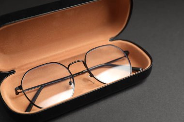 Gri arka planda şık gözlüklü çanta, yakın plan