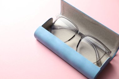 Pembe arka planda şık gözlüklü çanta, yakın plan.