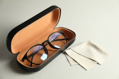 Şık gözlüklü çanta ve açık arkaplanda temizlik bezi.