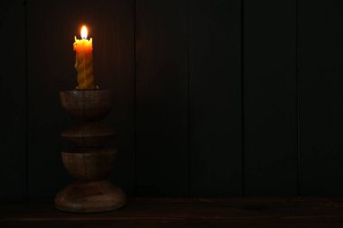 Ahşap masada yanan mum.
