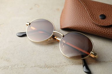 Güneş gözlüğü ve çanta ışık masasında, yakın plan.