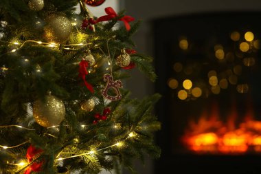Evdeki şöminenin yanında güzel dekore edilmiş Noel ağacı, yakın çekim. Bokeh etkisi