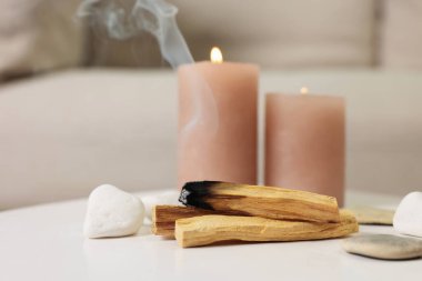 Palo Santo çubukları, yanan mumlar ve taşlar beyaz masa içinde, mesaj için yer