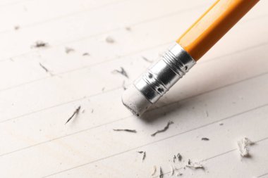 Beyaz kağıt üzerine silgi ile kalem kullanarak, yakın plan