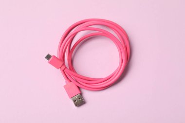 One USB charge cable on pink background, top view