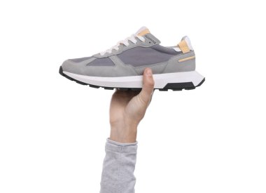 Beyaz arka planda şık spor ayakkabılı adam, yakın plan.