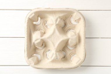 Beyaz ahşap masada boş karton bardak tutacağı, üst manzara.