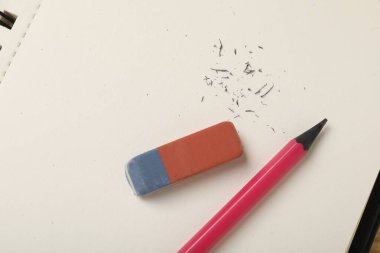 Silgi, kalem, kırıntılar ve defter masanın üstünde, üst görünümde