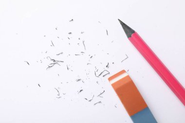 Eraser, pencil and scraps on white background, flat lay