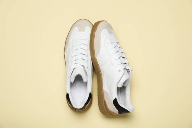 Pair of stylish sneakers on beige background, flat lay. Casual shoes