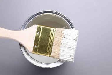 Gri arka planda beyaz boya ve fırça kutusu, üst görünüm