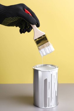 Renkli arka planda fırça ve beyaz boyalı adam, yakın plan