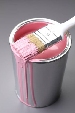 Gri arka planda pembe boya ve fırça kutusu