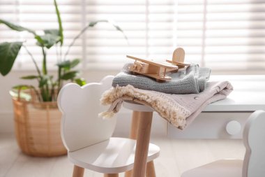 Toy plane and blankets on table in child's room